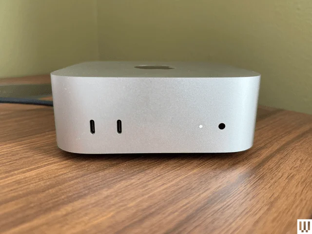 Front view of Apple Mac Mini M4 2024, a silver square shaped computer with small ports in the front