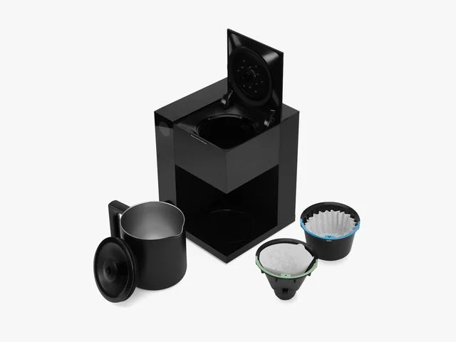Side view of Fellow Aiden Precision Coffee maker, a black rectangular maker, including filters and coffee pot