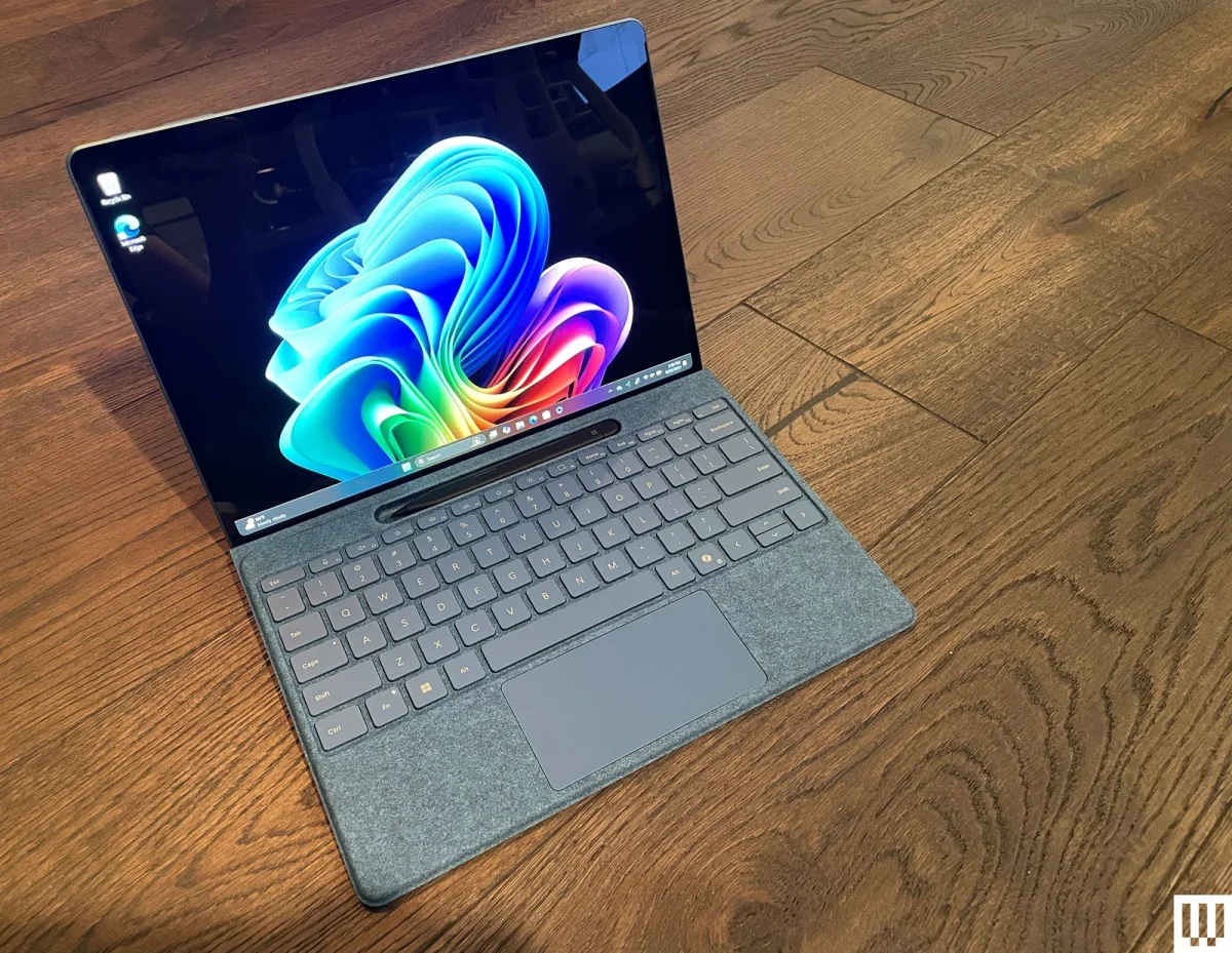 Microsoft Surface Pro tablet connected to detachable keyboard sitting on wooden floor.