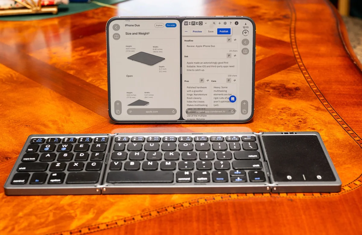 An iPhone Duo on a table with a keyboard.