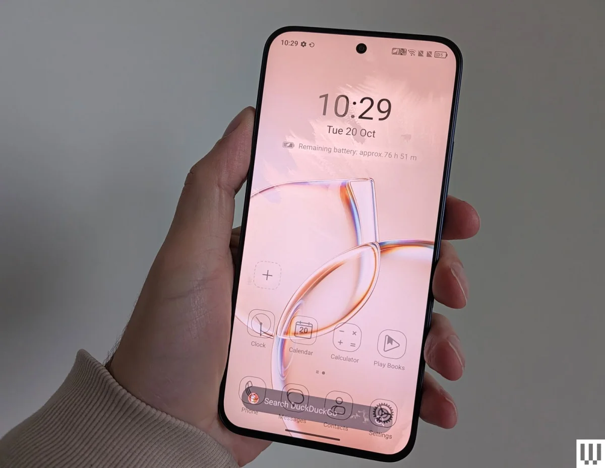 Hand holing a slim mobile phone with abstract art clock and apps on the homescreen