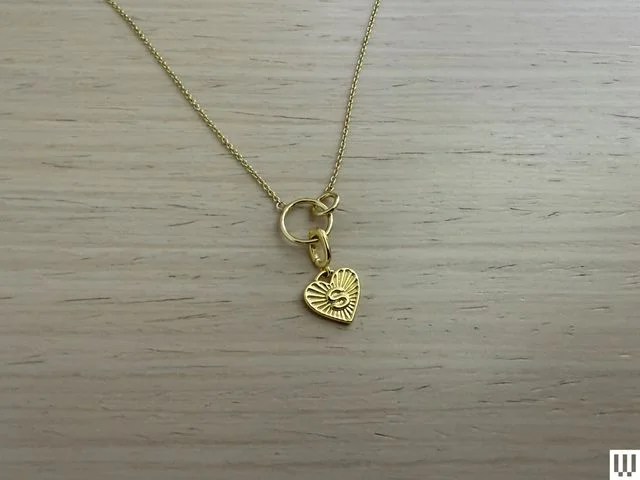 Gold necklace with heart-shaped pendant with the letter "S" on it