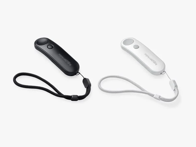 1 black and 1 white Kobo Remote, a slender handheld remote with a wrist strap