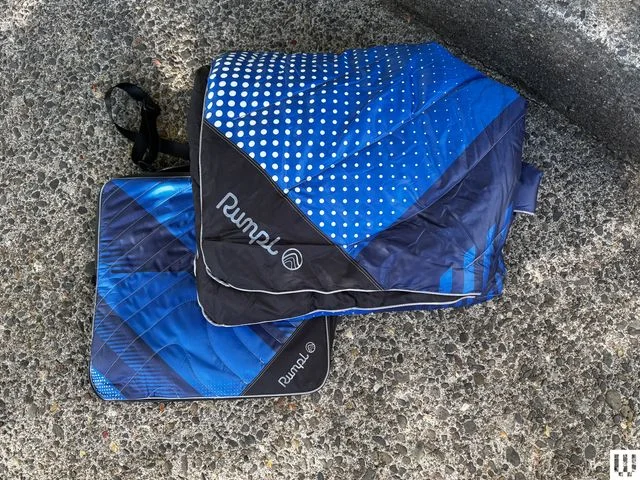 Puffy blanket folded up to a square pouch beside the same blanket unfolded